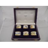 A set of six enamelled napkin rings with yellow metal bands, each depicting a different game bird,