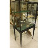 An ebonised framed and glazed five-sided display case with side door,