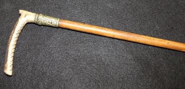 A child's riding crop with antler handle and plated ferrule with embossed decoration,