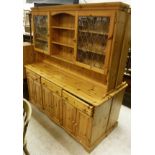 A modern pitch pine dresser, the upper section with three shelves flanked by leaded glazed doors