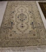 A Kashan rug, the central panel set with floral decorated medallion on a cream ground with floral