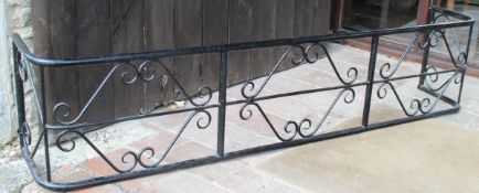 A black painted wrought iron fireguard of large proportions