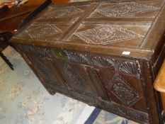 An 18th Century oak coffer of large proportions, the top in four diamond carved panels with