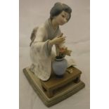A Lladro figure of a Japanese girl tending a flower in a vase, No'd. to base "J-27N"