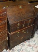 An 19th Century oak bureau, the fall front opening to reveal a fitted interior above two short and a