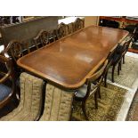 A reproduction mahogany rounded rectangular double pedestal extending dining table,