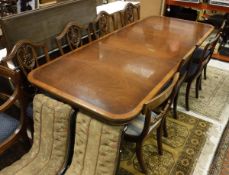 A reproduction mahogany rounded rectangular double pedestal extending dining table,