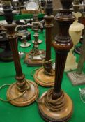 A pair of early 20th Century mahogany table lamps of reeded column form, together with another