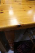 A modern pitch pine rectangular kitchen table raised on ringed and turned legs,
