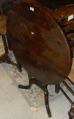 An early 19th Century oak snap top tea table, the circular top raised on turned pedestal to cabriole