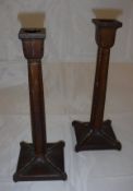 A pair of early 20th Century carved walnut candlesticks in the secessionist style