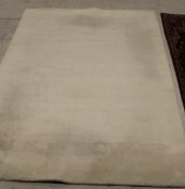 A modern rug of plain cream ground,
