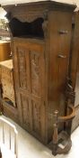 A late Victorian Gothic style carved oak hall stand with box seat and mirror flanked by hanging