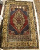 A Caucasian style rug, the central panel set with lozenge-shaped medallion on a blue and red