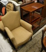 A Victorian armchair with pale gold upholstery, scroll arms raised on square section tapering legs
