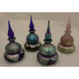 A collection of four Okra iradescent glass table scent bottles and stoppers,