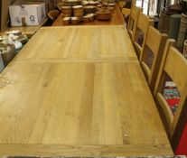 A light oak extending rectangular dining table on square section legs,