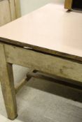A Victorian farmhouse kitchen table, the formica top with plain frieze on six square supports united