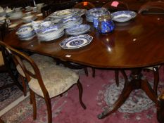 A reproduction mahogany D-end dining table raised on twin pedestal supports with hairy paw feet,