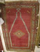 A Turkish style prayer rug, the central panel set with a chequer board effect, diamond-shaped