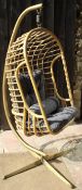 A bamboo hanging chair on a gold-sprayed metal frame
