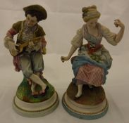 A pair of late 19th Century Continental matt polychrome decorated biscuit fired figures of