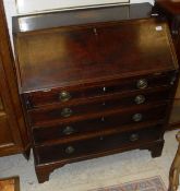 An early 19th Century mahogany and satinwood bureau, the sloping fall front enclosing a basic fitted