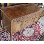 An Eastern hardwood sideboard with three central drawers flanked by single drawer and cupboard door,