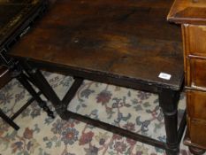 An 18th Century oak side table, the plain top supported by ringed and turned legs united by