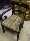 A Regency mahogany carver chair with carved top rail and back splat, over scrolled arms, raised on