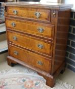 A walnut and banded bachelor's chest with fold-out top above four graduated drawers, raised on