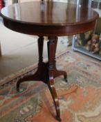 An early 19th Century mahogany and satinwood banded circular centre table, raised on a base of three