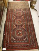 A Belouch tribal rug, the central panel set with four repeating medallions on a red and blue