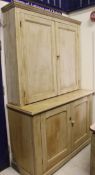 A 19th Century pine cupboard, the panelled doors enclosing partitioned shelves on a base of two