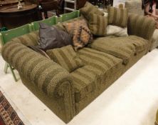 A modern three seat sofa with scroll arms and patterned striped brown upholstery with various