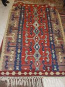 A Kelim rug in yellow, blue, red and mushroom, together with a Dutch rug/throw of Bokhara design,