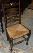 A set of six oak ladder back dining chairs with rush seats, raised on turned legs to stretchered
