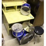 A child's yellow painted desk and a miniature drum kit