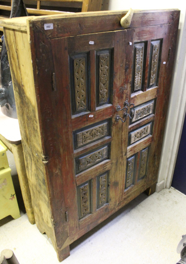 An Eastern painted pine two panelled door cupboard enclosing three shelves to stile feet