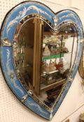 A Venetian style wall mirror in the form of a stylised love heart with blue etched border