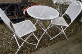 A white painted metal bistro set comprising folding table and two chairs