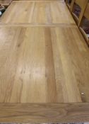 A light oak extending rectangular dining table on square section legs,