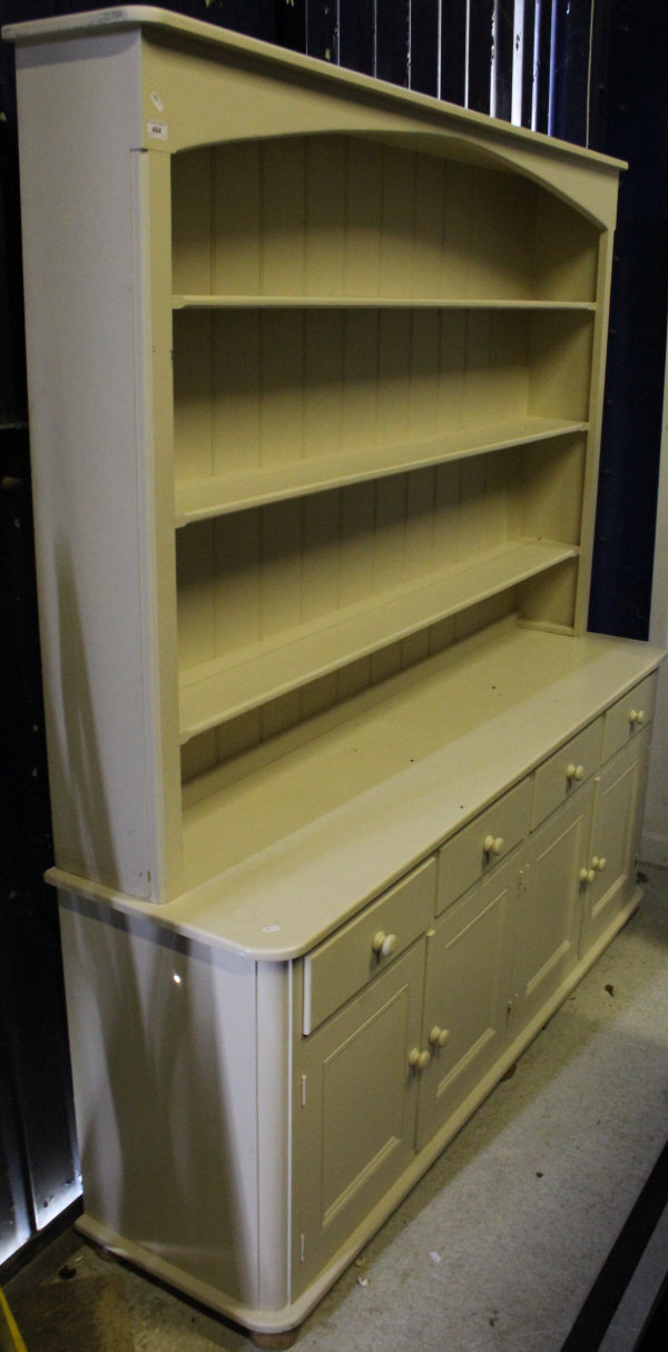 A painted pine dresser with open shelves above a base of four drawers to four cupboard doors