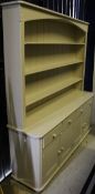 A painted pine dresser with open shelves above a base of four drawers to four cupboard doors