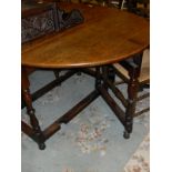 An early 20th Century oak gate-leg dining table with baluster turned supports and stretchered base