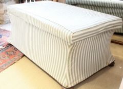 A white and green stripe upholstered ottoman on mahogany bun feet