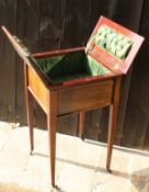 A mahogany and satinwood banded work table, the fold-out top opening to reveal a green buttoned silk