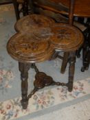 A late 19th Century oak occasional table with clover shaped carved top to three turned supports