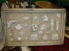 A framed display board with various plaster moulds