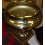 A large modern lacquered brass pedestal bowl on square stepped foot